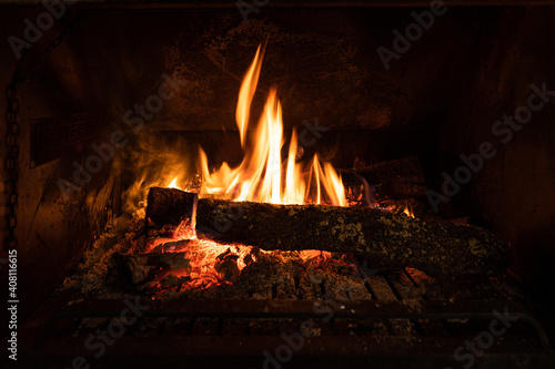 Close-up photo of a bonfire with long flames burning a trunk