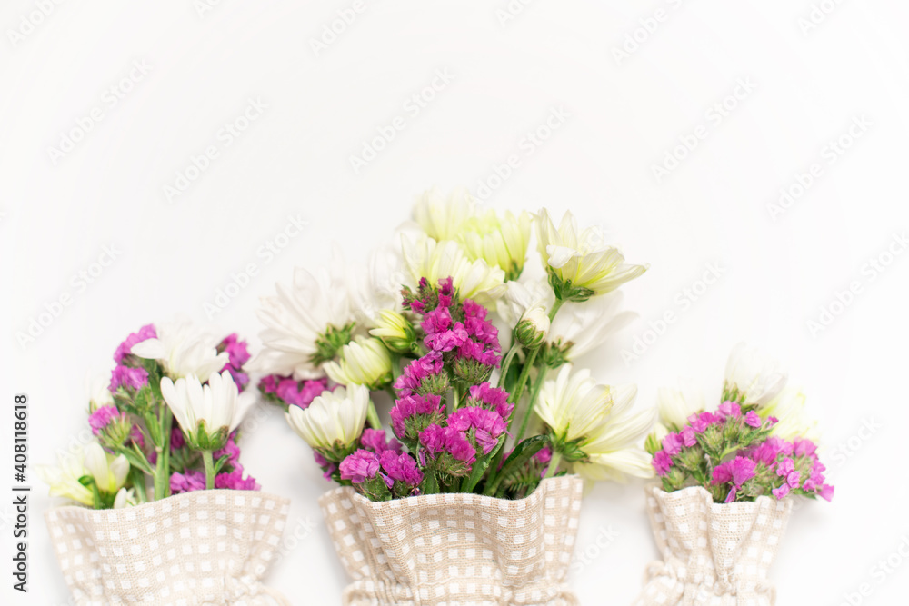 Pink statice and white chrysanthemum flowers on a white background. Top view. Copy space. Space for the text. The concept of the holiday.