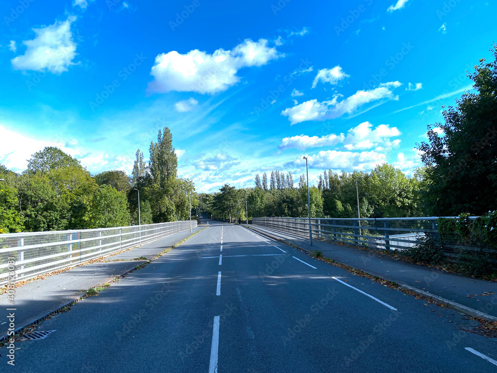 The bridge over the M62 motorway, on  Whitechapel Road, with old trees, and a blue sky in, Cleckheaton, Yorkshire, UK