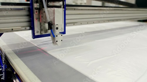 Laser cuts white spunbond fabric to sew protective clothes photo