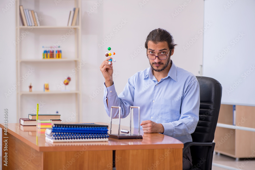 Young male teacher physicist in the classroom Young male teacher physicist in the classroom