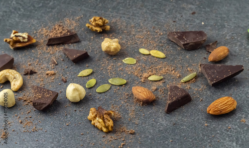 Nuts, chocolate and pumpkin seeds on the stone surface