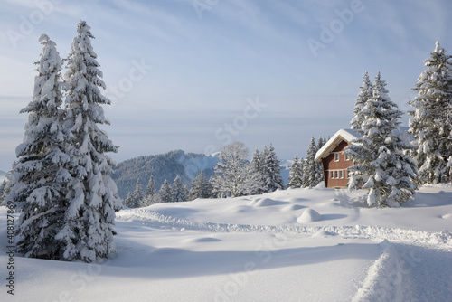un chemin de randonnée hivernal en montagne passant devant un chalet - Alpes Suisse © DOMINIQUE MARIOTTI