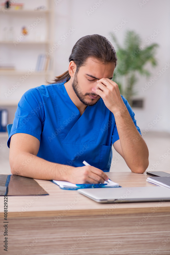 Young male doctor working in the clinic Young male doctor working in the clinic