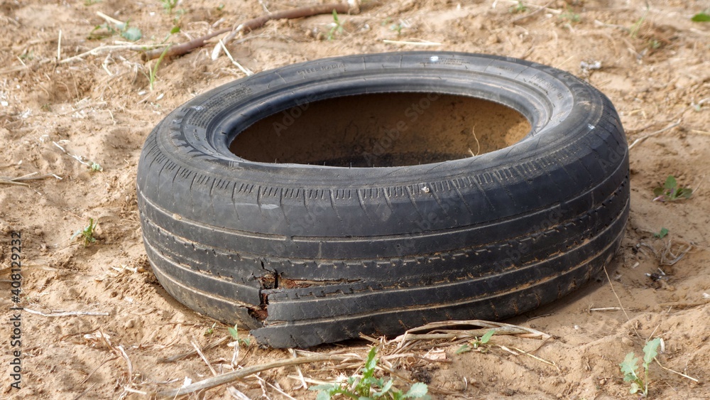 Rajasthan, India - January 20, 2021: A used rubber wheel of car on the ground. damaged tires for recycling waste management industry