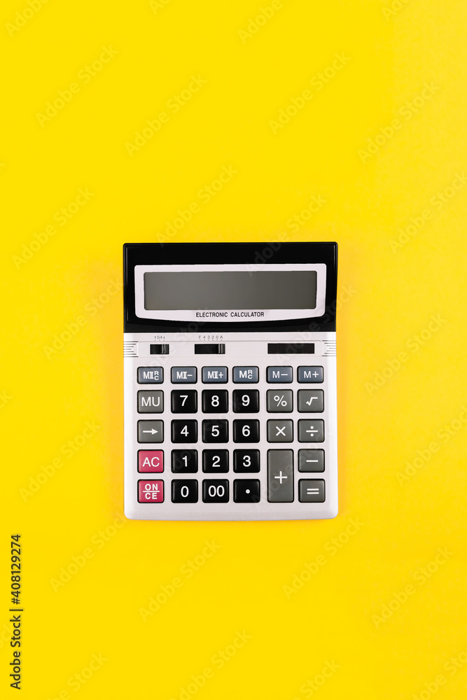 Large silver calculator with black buttons on yellow background with copy space. Conceptual photo of calculation, counting, accounting, computing, profit, loss, tax. Business card. Digital stationery Large silver calculator with black buttons on yellow background with copy space. Conceptual photo of calculation, counting, accounting, computing, profit, loss, tax. Business card. Digital stationery