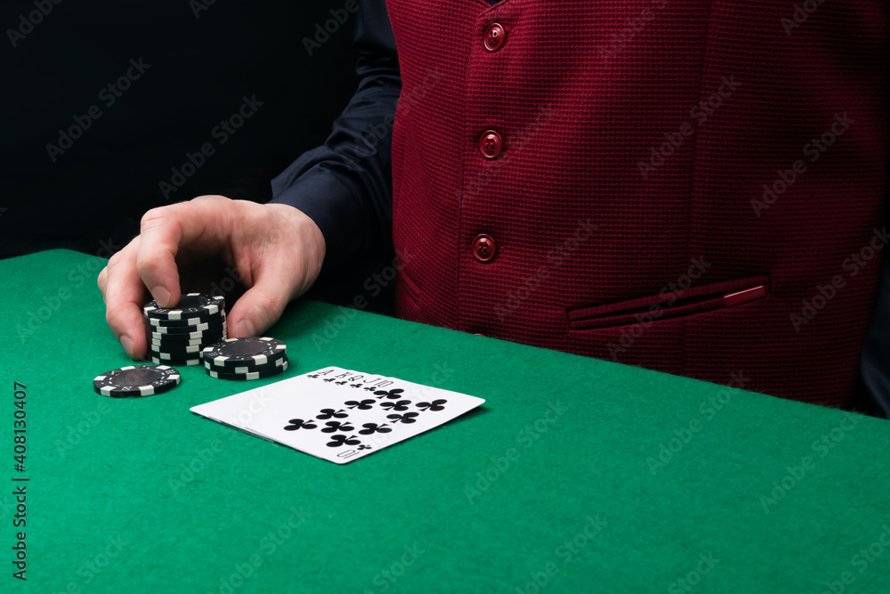 black suit and chips for playing poker or blackjack, on the green table in front of the player, there is a place for the inscription black suit and chips for playing poker or blackjack, on the green table in front of the player, there is a place for the inscription