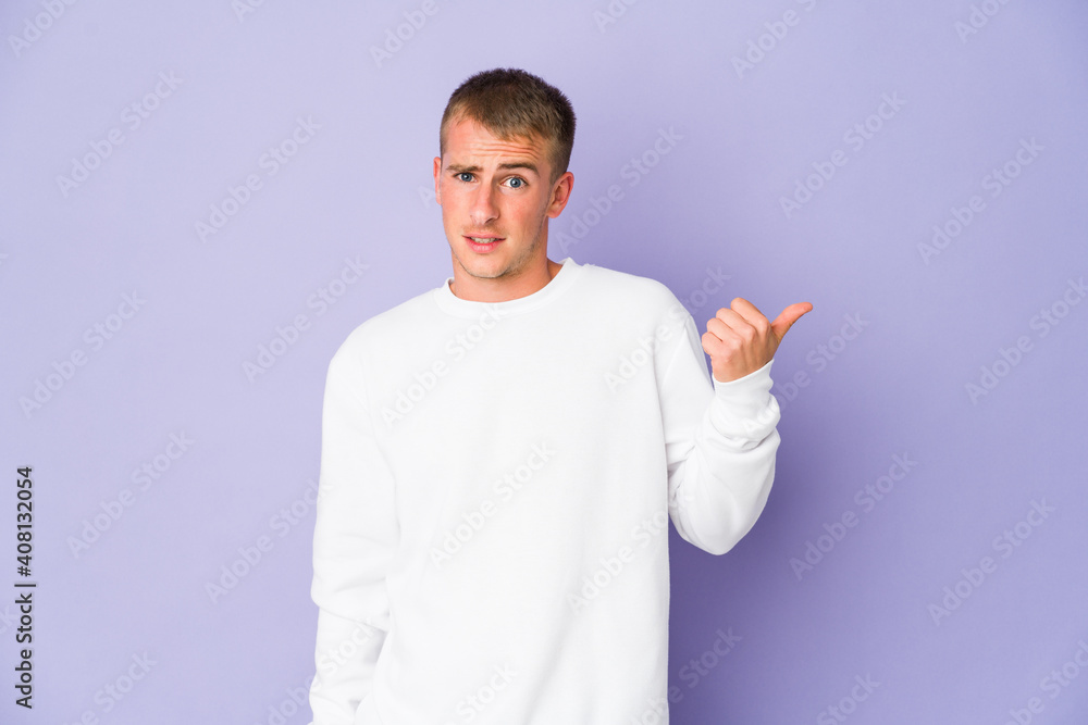 Young caucasian handsome man shocked pointing with index fingers to a copy space. Young caucasian handsome man shocked pointing with index fingers to a copy space.