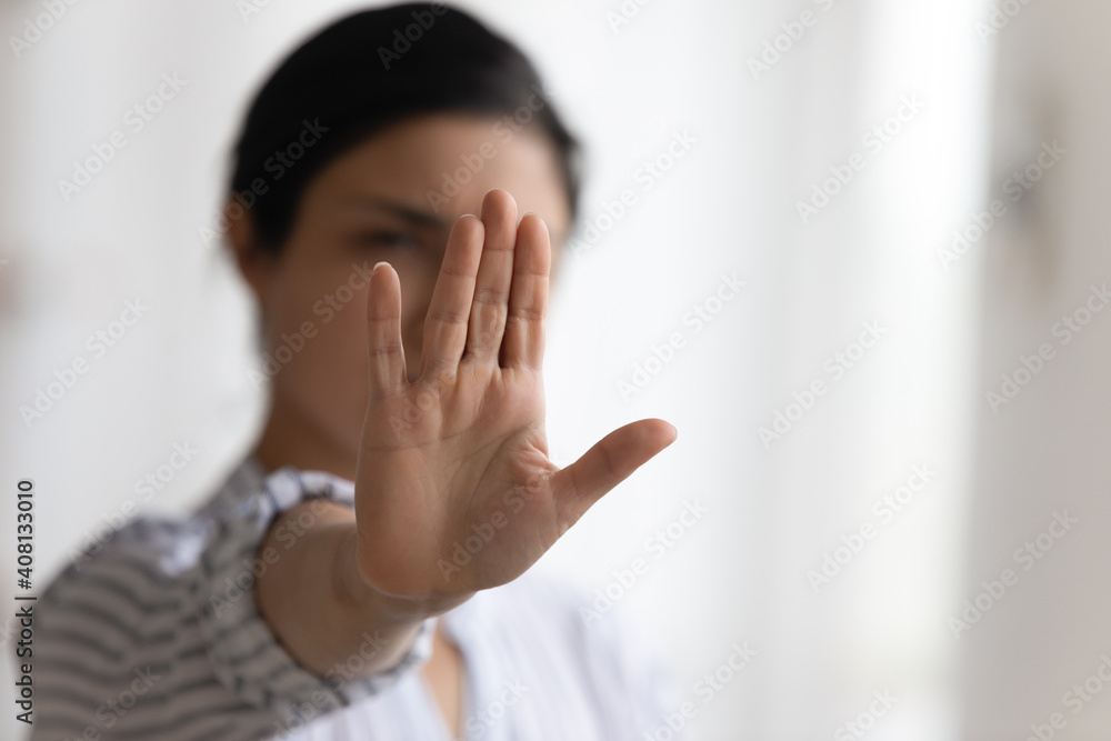 Stop it. Determined millennial lady strongly resist domestic violence against women gender discrimination bullying abuse. Focus on female palm raising up to camera in forbidding gesture. Copy space Stop it. Determined millennial lady strongly resist domestic violence against women gender discrimination bullying abuse. Focus on female palm raising up to camera in forbidding gesture. Copy space