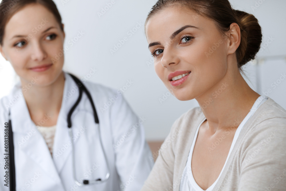 Doctor and patient are sitting and discussing health examination results in clinic office. Health care, medicine and good news concepts Doctor and patient are sitting and discussing health examination results in clinic office. Health care, medicine and good news concepts