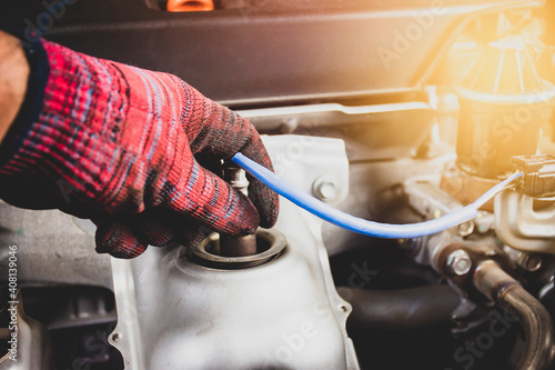 Konstfotografi The mechanic is opening oxygen sensor O2 in the exhaust pipe for calculating the