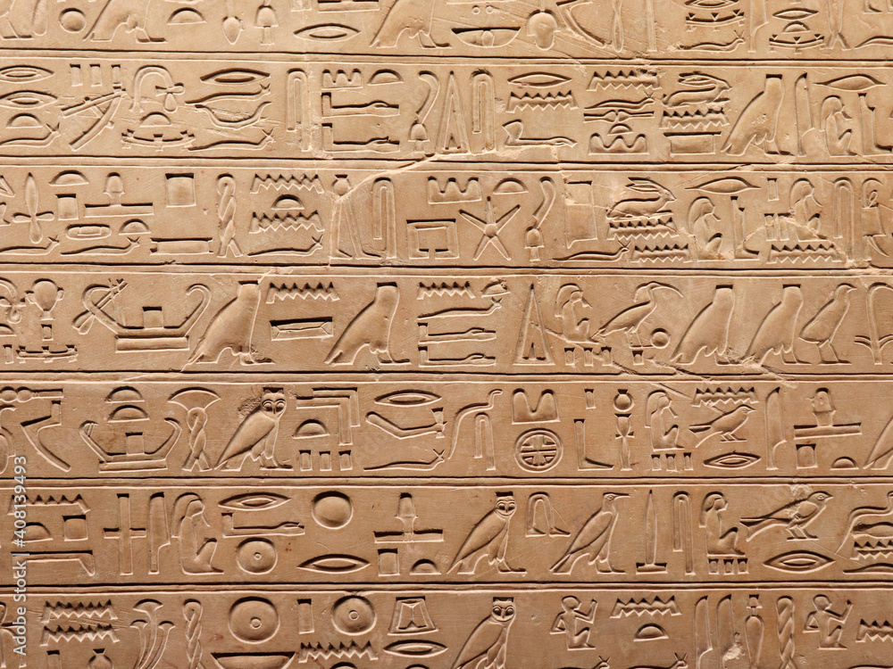 Egyptian hieroglyphs on a stone wall. The language of an ancient civilization.