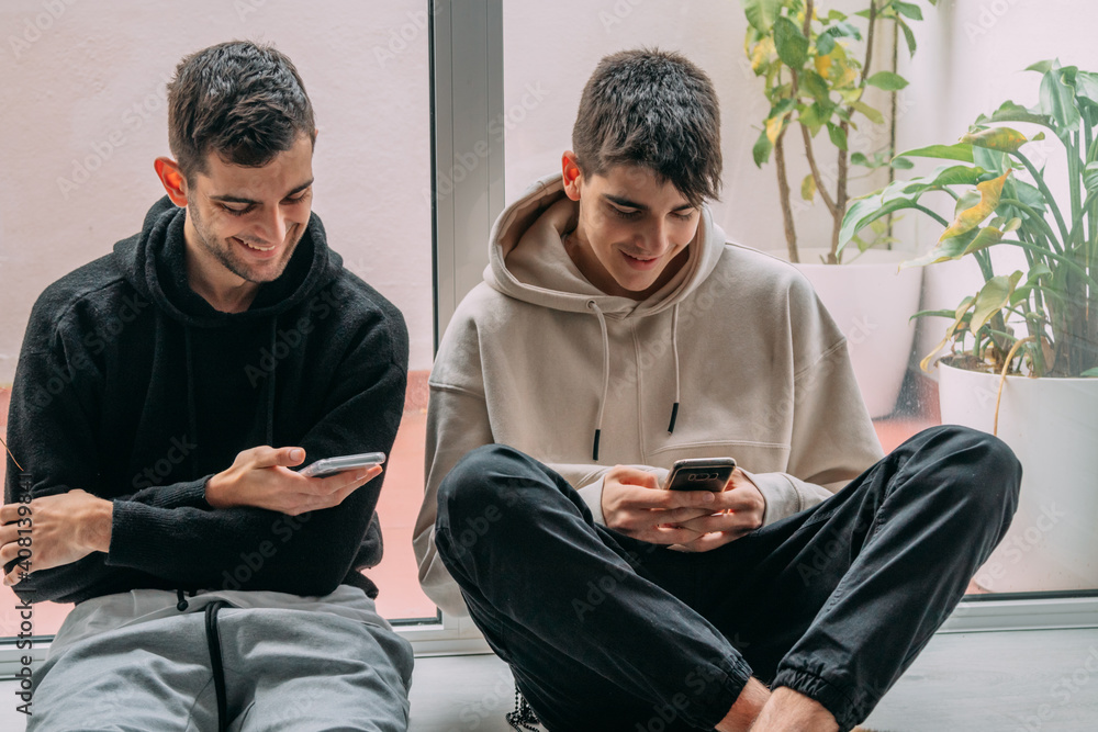 young people with mobile phones at home sitting comfortably young people with mobile phones at home sitting comfortably