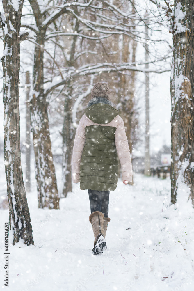 teen girl walks on a snow-covered path in winter, a teenage boy and a girl, a snowstorm