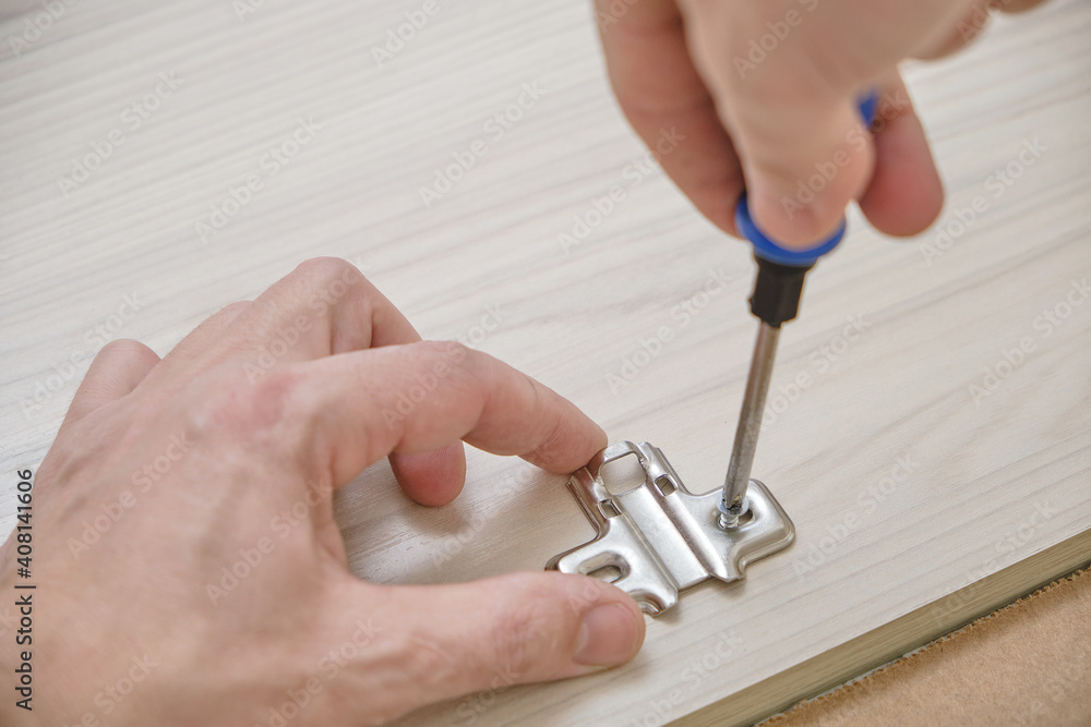 Master attaches hardware to furniture parts.Assembly of cabinet furniture. Master attaches hardware to furniture parts.Assembly of cabinet furniture.