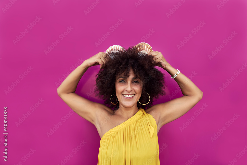 Woman with afro hair. She has a yellow dress and behind is a purple background
Woman with afro hair. She has a yellow dress and behind is a purple background