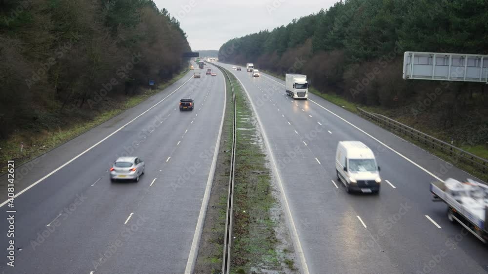 The M1 Motorway road in the UK. Cars and lorries travel along the highway in England on a wet winter day. The M1 Motorway road in the UK. Cars and lorries travel along the highway in England on a wet winter day.