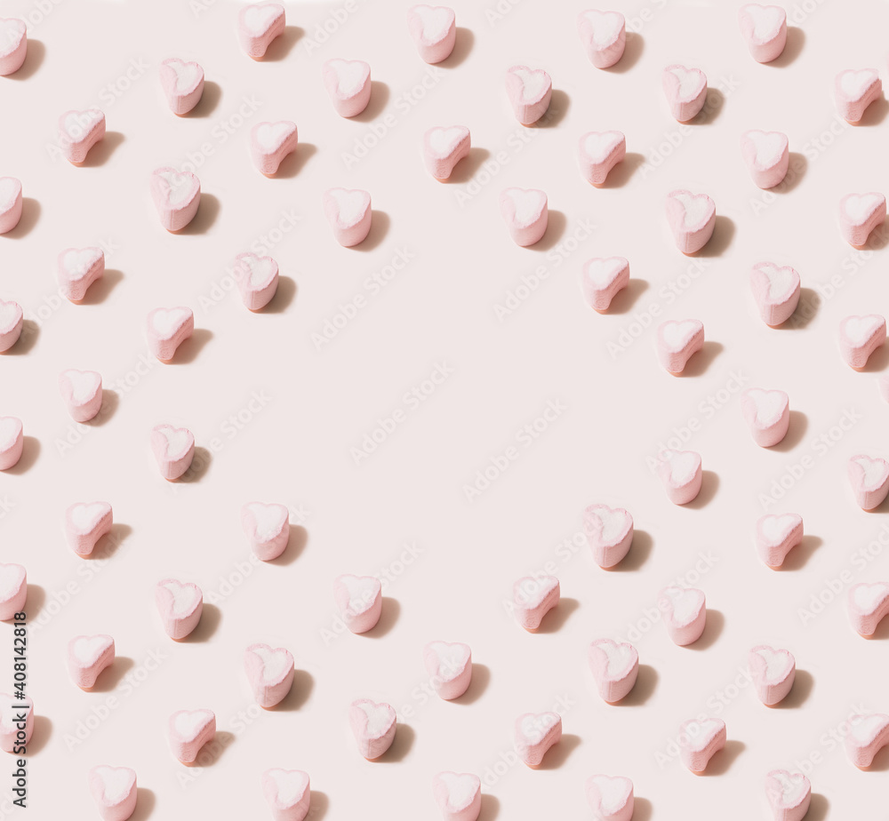Isometric pattern created of heart marshmallows in pink and white color. 45 degree angle on pastel beige background with a central copy space.