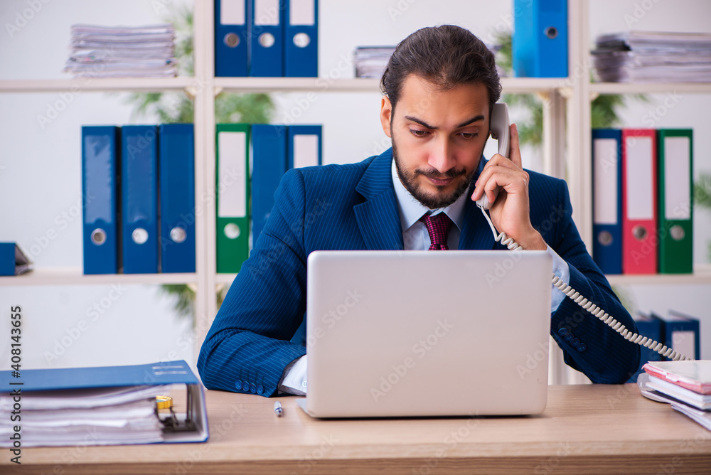 Young male employee and too many work in the office Young male employee and too many work in the office