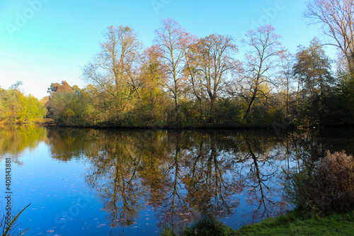 Beautiful pastoral view from Vondelpark in Amsterdam, Netherlands. Autumn trees and their reflections on the lake. 