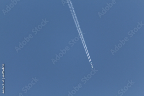 Estela de un avión sobre el cielo azul sin nubes. Horizontal.