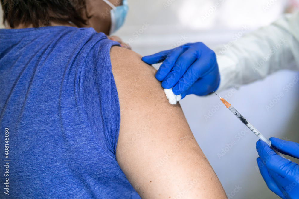 close up doctor holding syringe and using cotton before make injection to patient in medical mask. Covid-19 or coronavirus vaccine close up doctor holding syringe and using cotton before make injection to patient in medical mask. Covid-19 or coronavirus vaccine