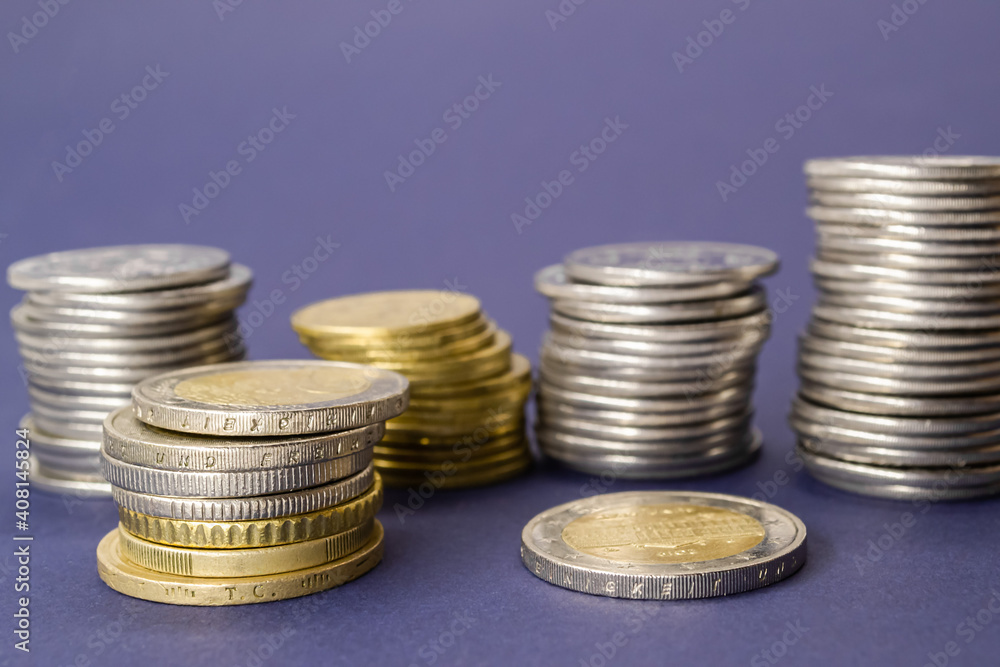 Stacks of coins from different countries on a purple background Stacks of coins from different countries on a purple background