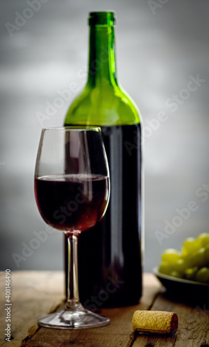 A bottle of wine on a wooden table in a dark cellar