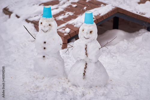 dancing snowmans with blue hats in the park. winter entertainment
