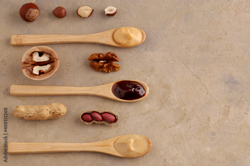 Butter, nut paste in wooden spoons with ingredients on a light background. Homemade Raw Organic Hazelnut, Peanut, Walnut. Concept for natural and vegetarian products. Top view, flatlay. Copy space. Butter, nut paste in wooden spoons with ingredients on a light background. Homemade Raw Organic Hazelnut, Peanut, Walnut. Concept for natural and vegetarian products. Top view, flatlay. Copy space.