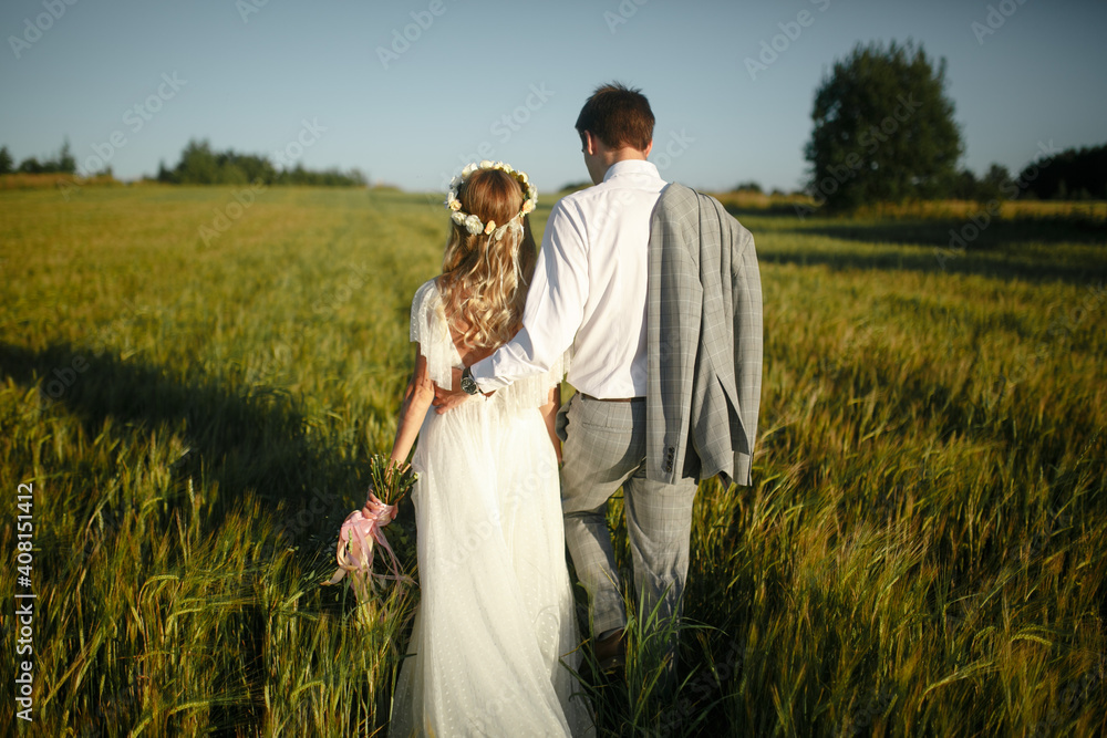 Back view of the groom and the bride in the field. Back view of the groom and the bride in the field.