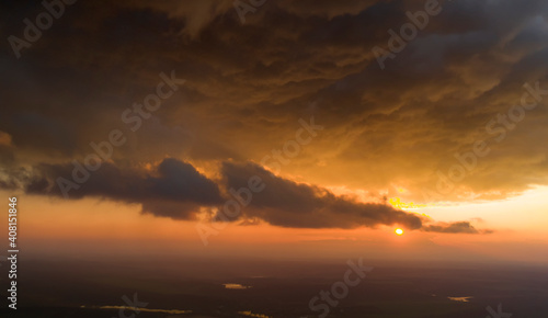 Dramatic sunset, the sun's rays shine through the clouds. © maykal