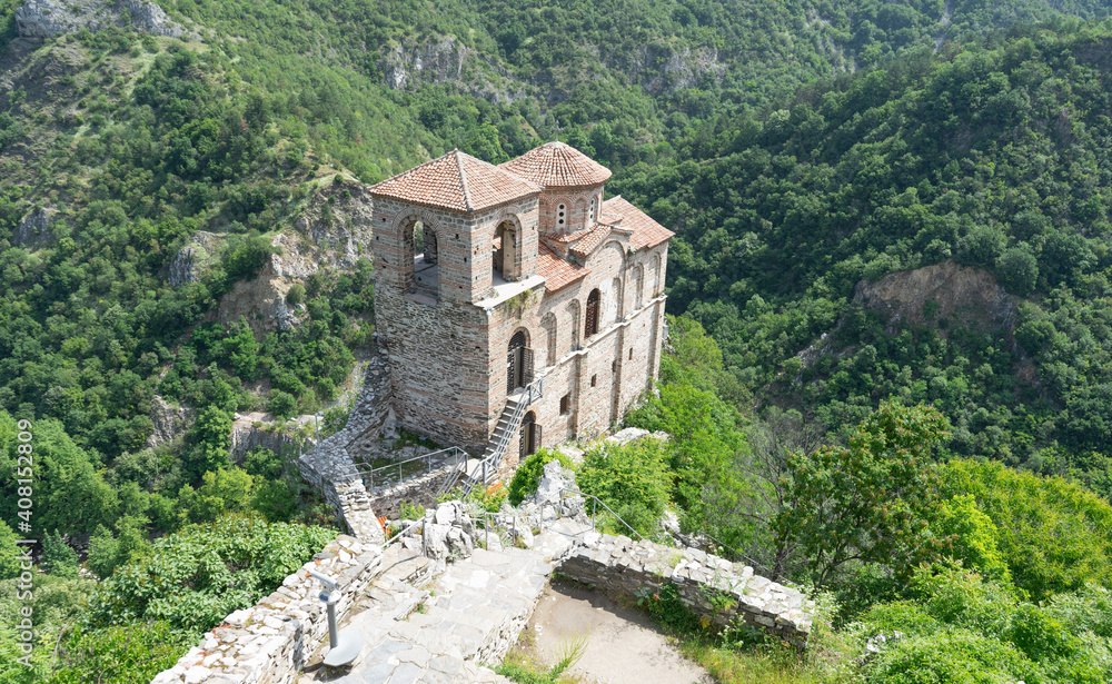 Medieval Fortress Asen , on a hill in eastern Europe, Bulgaria. Bulgarian antique and heritage stronghold fortification on a rock. Aerial view of a holy place and monastery. Tourist place with forest.