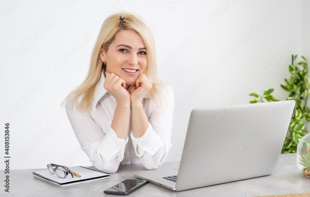 Beautiful young woman working on her laptop in her office. Beautiful young woman working on her laptop in her office.