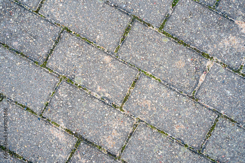 a rectangular gray pavement on the ground is sprinkled with yellow sand