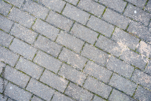 a rectangular gray pavement on the ground is sprinkled with yellow sand