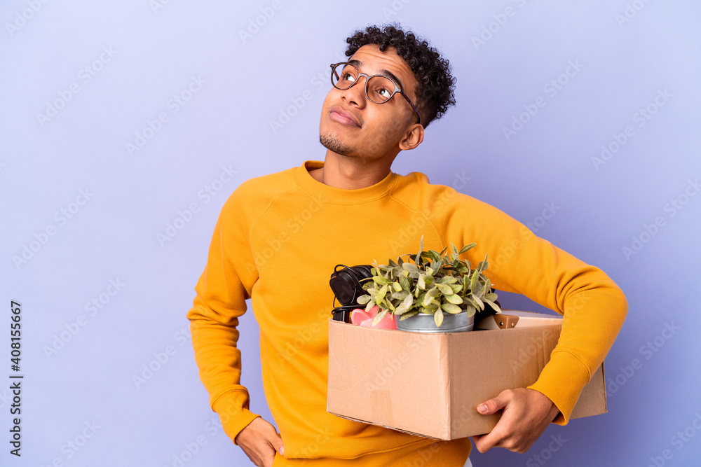 Young african american curly man isolated moving to a new home dreaming of achieving goals and purposes Young african american curly man isolated moving to a new home dreaming of achieving goals and purposes