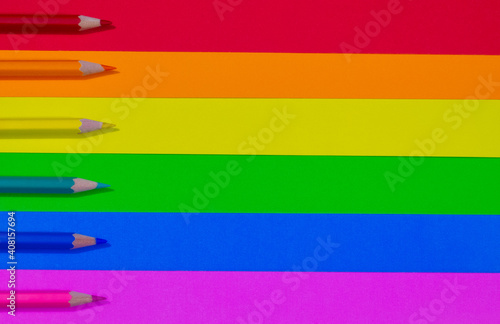 Free Download colored pencils on a lgbt flag made of cardboard,each pencil placed on the same color and ordered red, orange, yellow, green, blue, purple, with space for text - GFXLoad