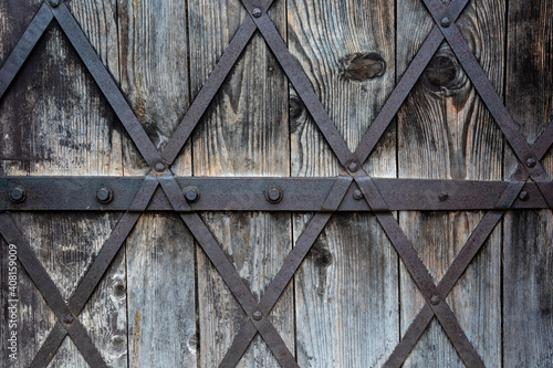 close-up of an old castle wooden door where we can see there is metal wire
