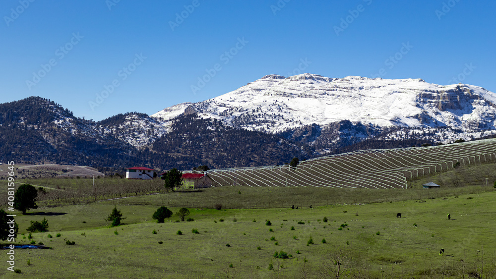 Beautiful Taurus mountains in Turkey view after the snow with farms on a sunny day