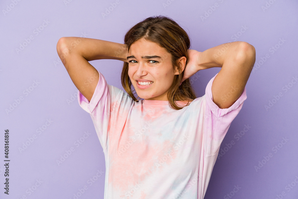 Young skinny caucasian girl teenager on purple background touching back of head, thinking and making a choice. Young skinny caucasian girl teenager on purple background touching back of head, thinking and making a choice.