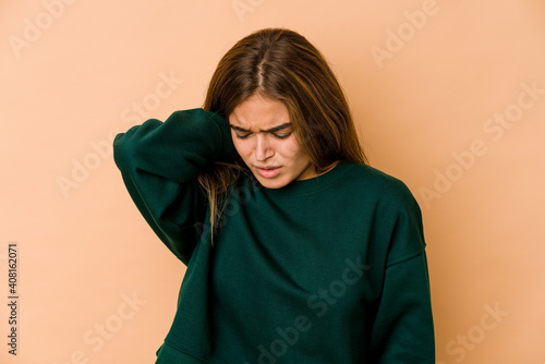 Young skinny caucasian teenager girl having a neck pain due to stress, massaging and touching it with hand. © Asier