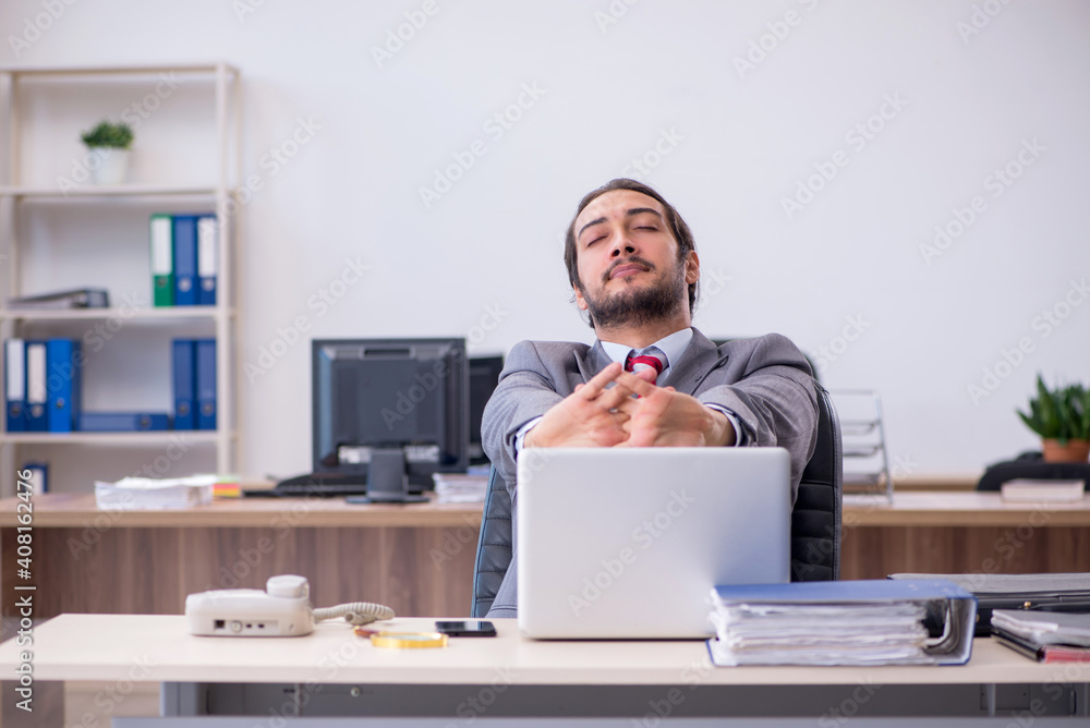 Young male employee working in the office Young male employee working in the office