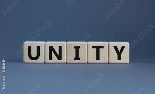 Time to unity symbol. Concept word unity on wooden cubes on a beautiful grey background. Business and unity concept. Copy space.