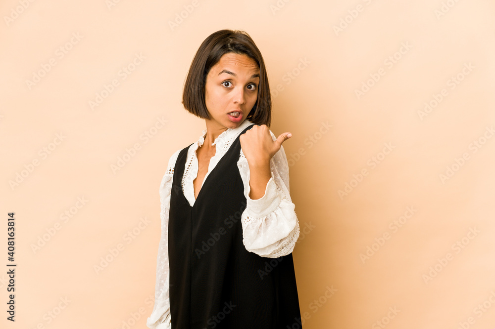 Young hispanic woman isolated points with thumb finger away, laughing and carefree. Young hispanic woman isolated points with thumb finger away, laughing and carefree.