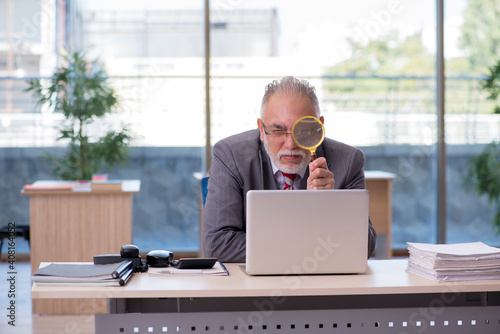 Aged businessman employee working in the office © Elnur