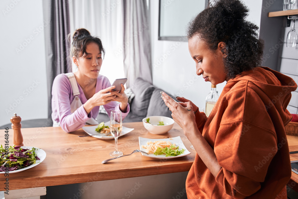 Girls using smartphones while having dinner