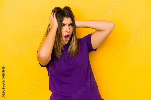 Young indian woman isolated on yellow background screaming, very excited, passionate, satisfied with something.