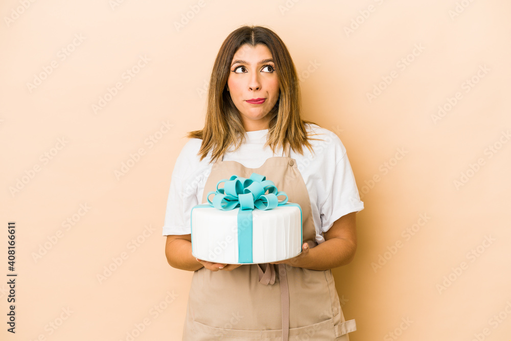 Young indian pastry chef woman isolated confused, feels doubtful and unsure. Young indian pastry chef woman isolated confused, feels doubtful and unsure.