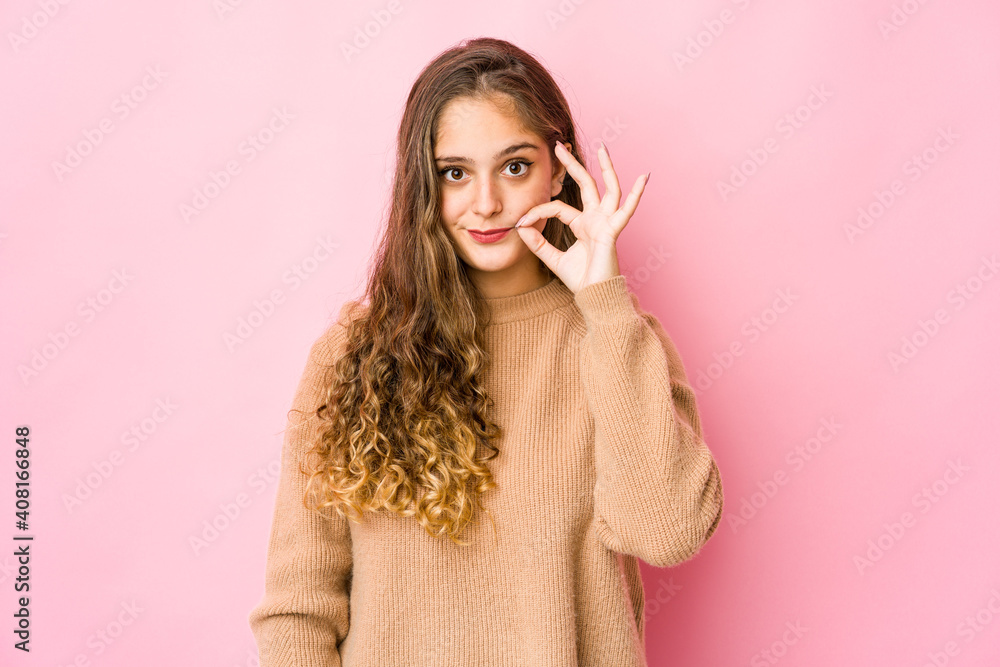 Young caucasian woman with fingers on lips keeping a secret.